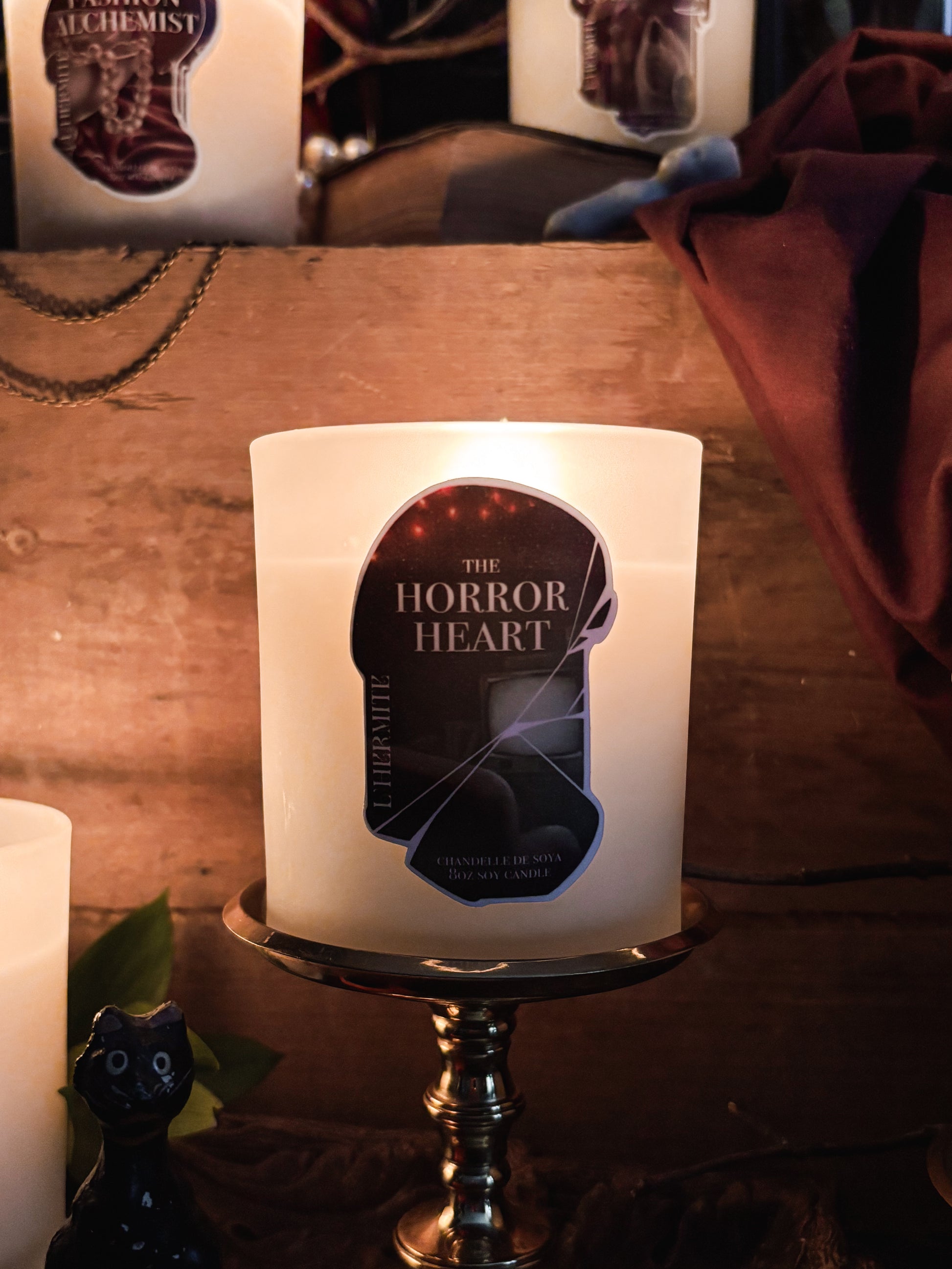 Candle with 'The Horror Heart' label on a wooden surface