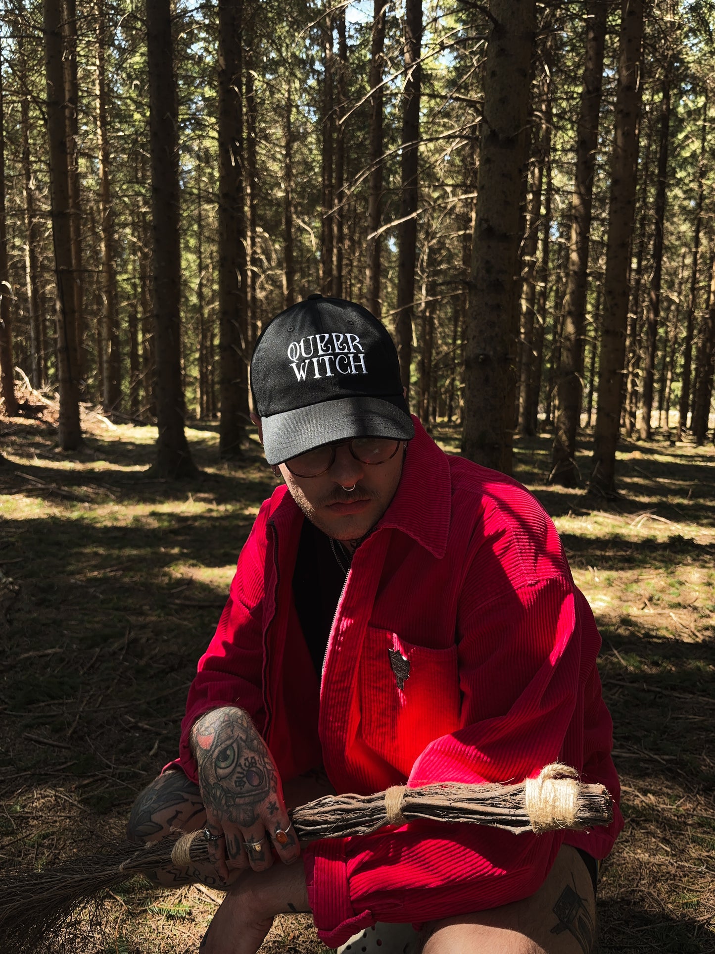 Black embroidered dad hat with 'Queer Witch' stitched in bold lettering. A perfect everyday spell for visibility.
