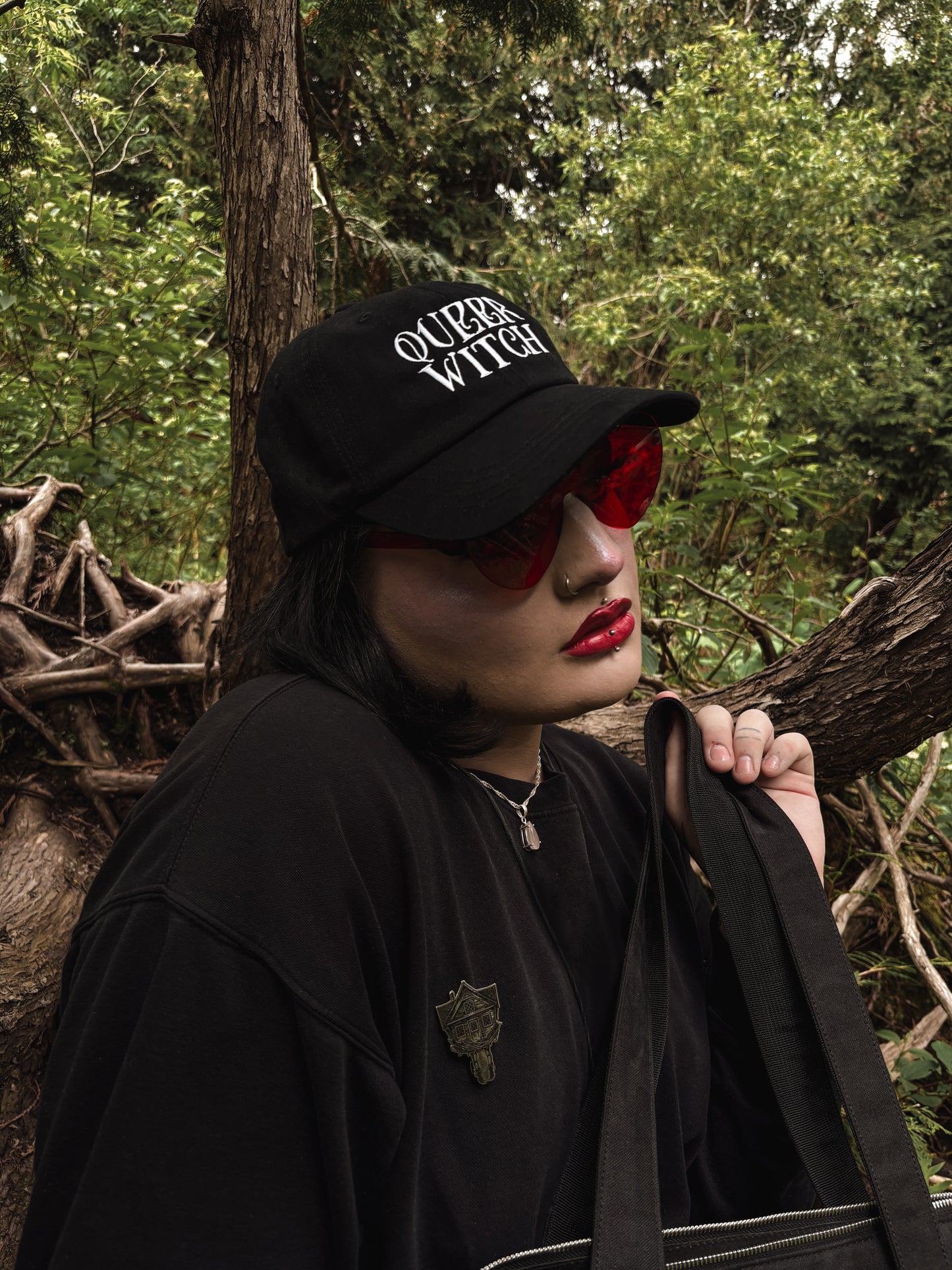 Black embroidered dad hat with 'Queer Witch' stitched in bold lettering. A perfect everyday spell for visibility.