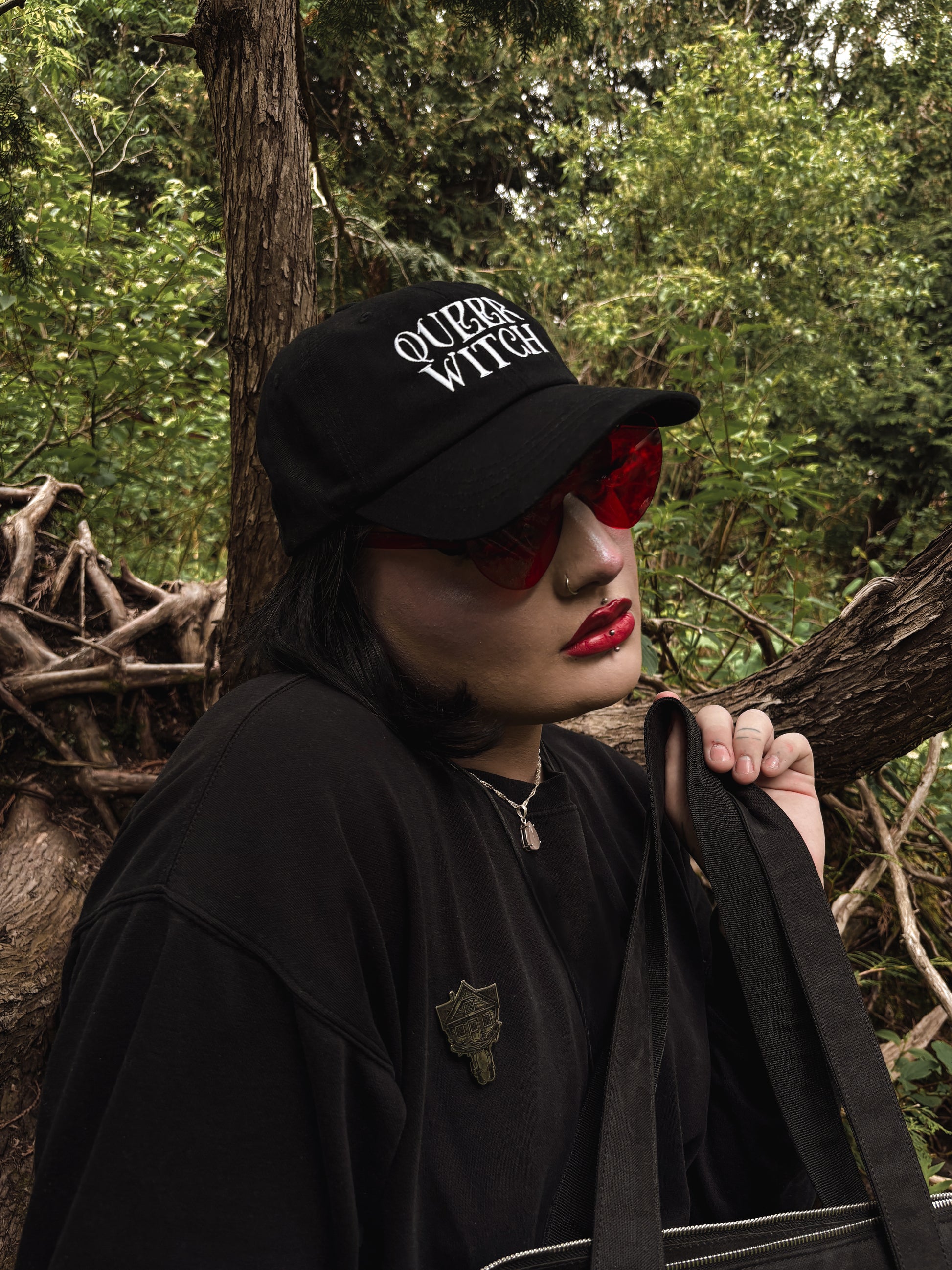 Black embroidered dad hat with 'Queer Witch' stitched in bold lettering. A perfect everyday spell for visibility.