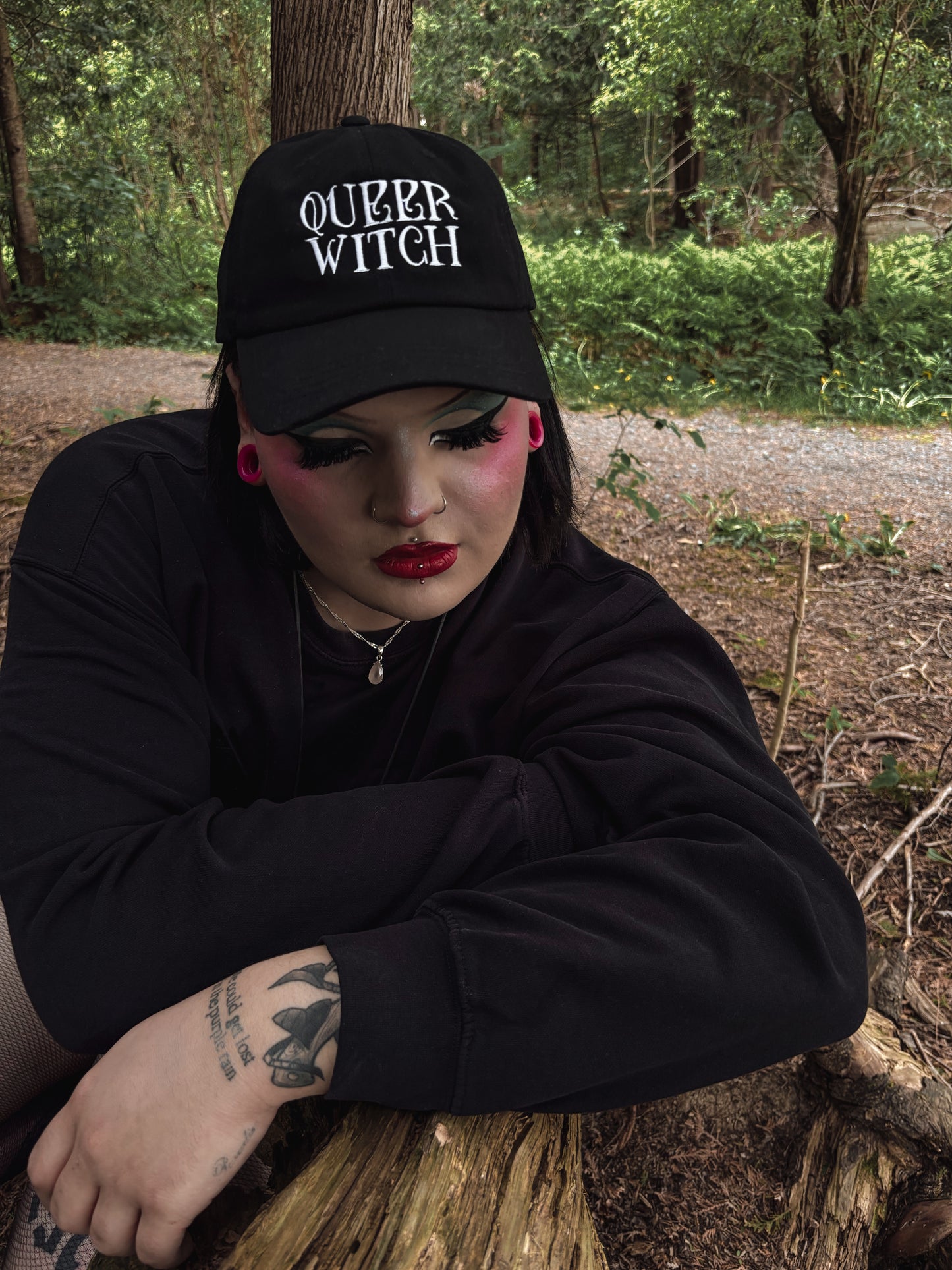 Black embroidered dad hat with 'Queer Witch' stitched in bold lettering. A perfect everyday spell for visibility.