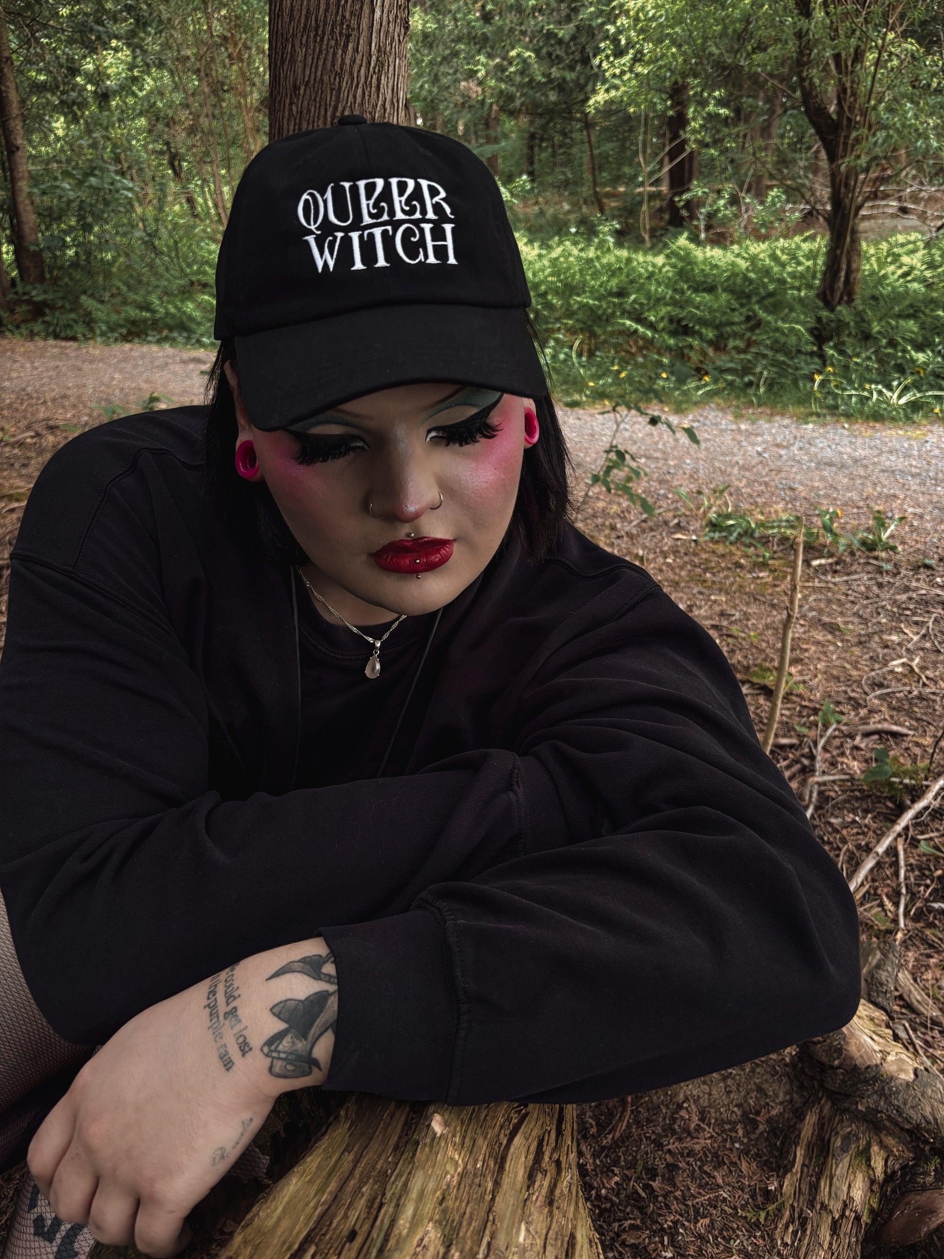 Black embroidered dad hat with 'Queer Witch' stitched in bold lettering. A perfect everyday spell for visibility.