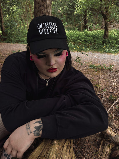 Black embroidered dad hat with 'Queer Witch' stitched in bold lettering. A perfect everyday spell for visibility.