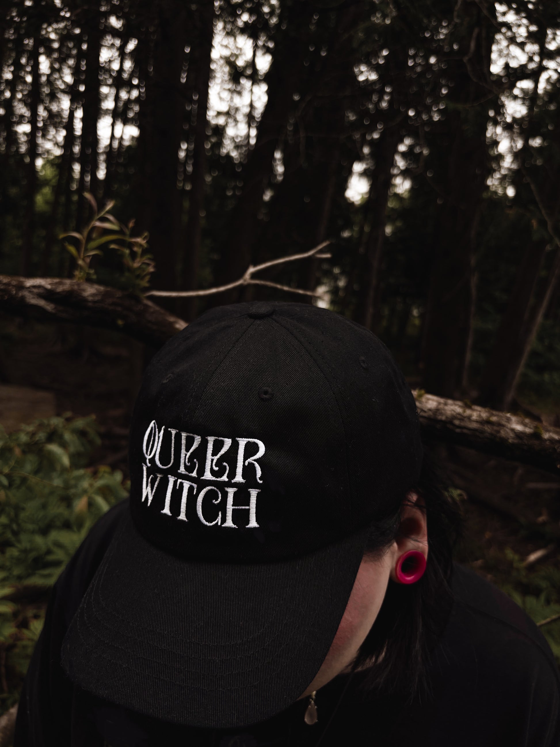 Black embroidered dad hat with 'Queer Witch' stitched in bold lettering. A perfect everyday spell for visibility.