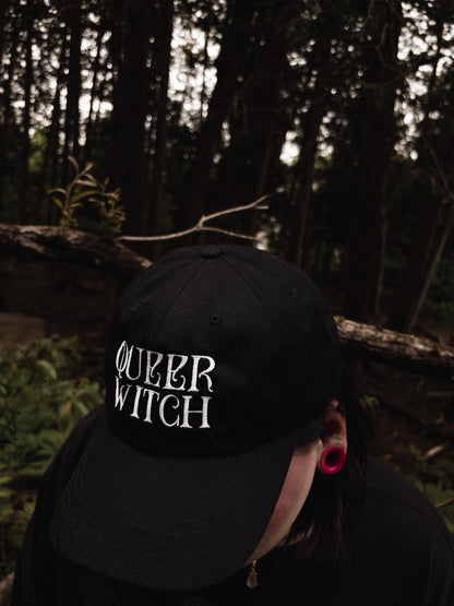 Black embroidered dad hat with 'Queer Witch' stitched in bold lettering. A perfect everyday spell for visibility.